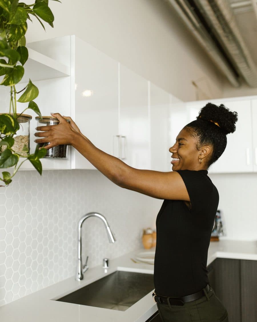 Une gouvernante range les placards d'une cuisine